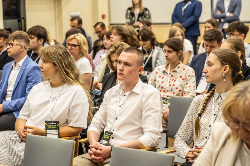 Publiczność patrząca na mężczyznę przemawiającego przy mównicy
