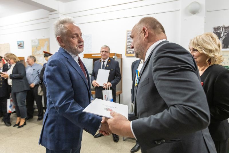 Marszałek wręczający dyplom mężczyźnie w garniturze