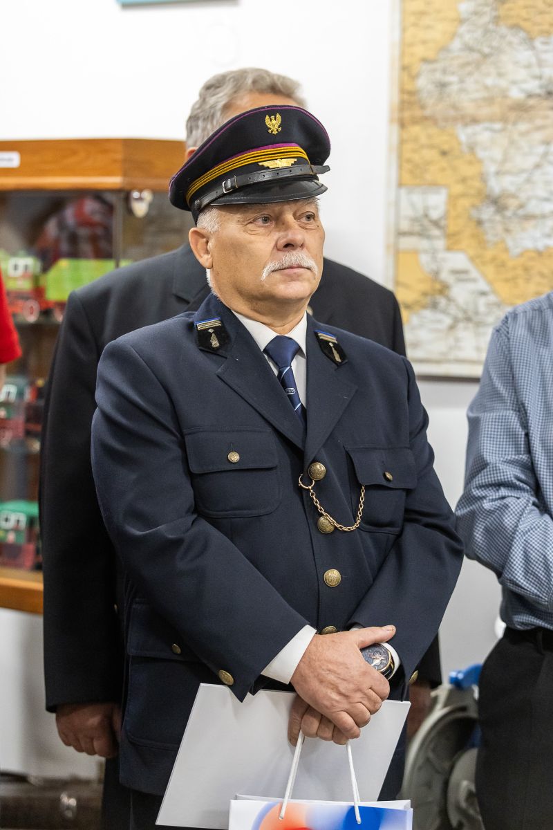Mężczyzna w mundurze kolejowy patrzący na mównice