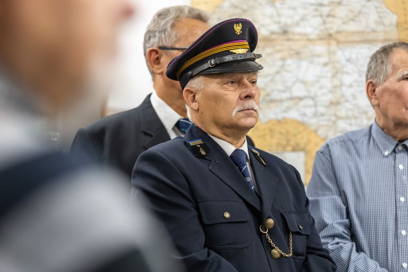Mężczyzna w mundurze kolejowy patrzący na mównice