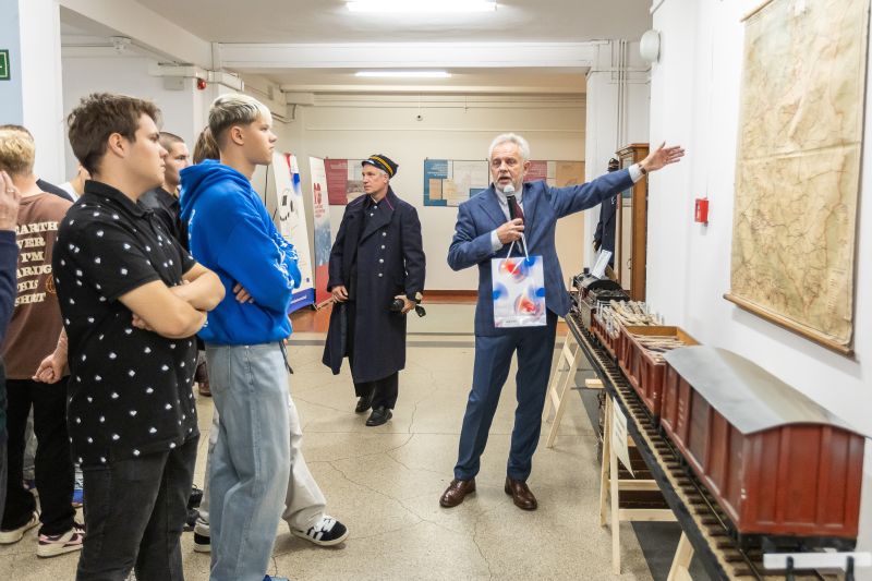Mężczyzna w garniturze prezentujący zdjęcia publiczności