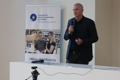 Profesor przemawiający do uczestników konferencji