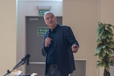 Profesor przemawiający do uczestników konferencji