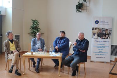 Prelegenci dyskutujący przed zebranymi na konferencji