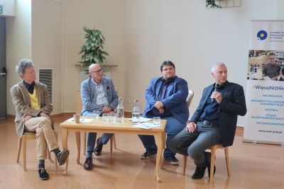 Prelegenci dyskutujący przed zebranymi na konferencji