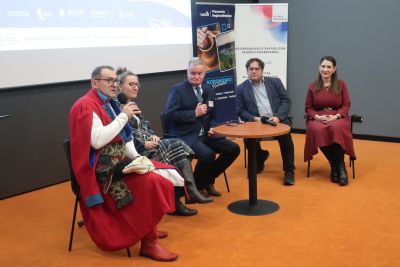 Zaproszeni na konferencję dyskutujący przy zgromadzonych