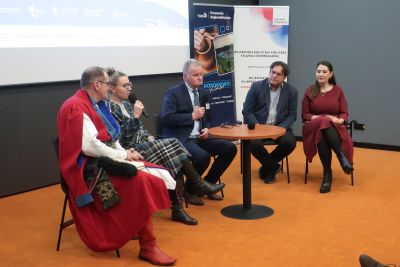 Zaproszeni na konferencję dyskutujący przy zgromadzonych