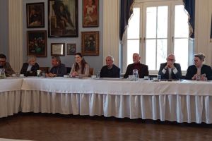 widok sali, osoby siedzą za stołem