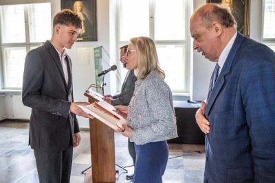 Dyrektor Kamila Łajczak oraz Profesor Polak pozujący do zdjęcia z laureatem konkursu