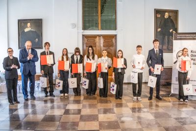 Profesor Polak pozujący do zdjęcia wraz z laureatami konkursu