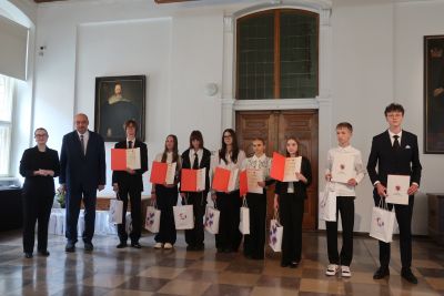 Profesor Polak pozujący do zdjęcia wraz z laureatami konkursu