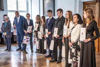Profesor Polak pozujący do zdjęcia wraz z laureatami konkursu