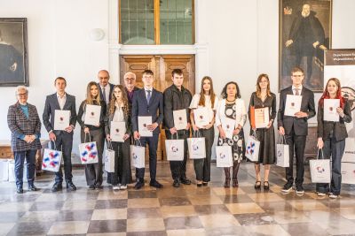 Profesor Polak pozujący do zdjęcia wraz z laureatami konkursu